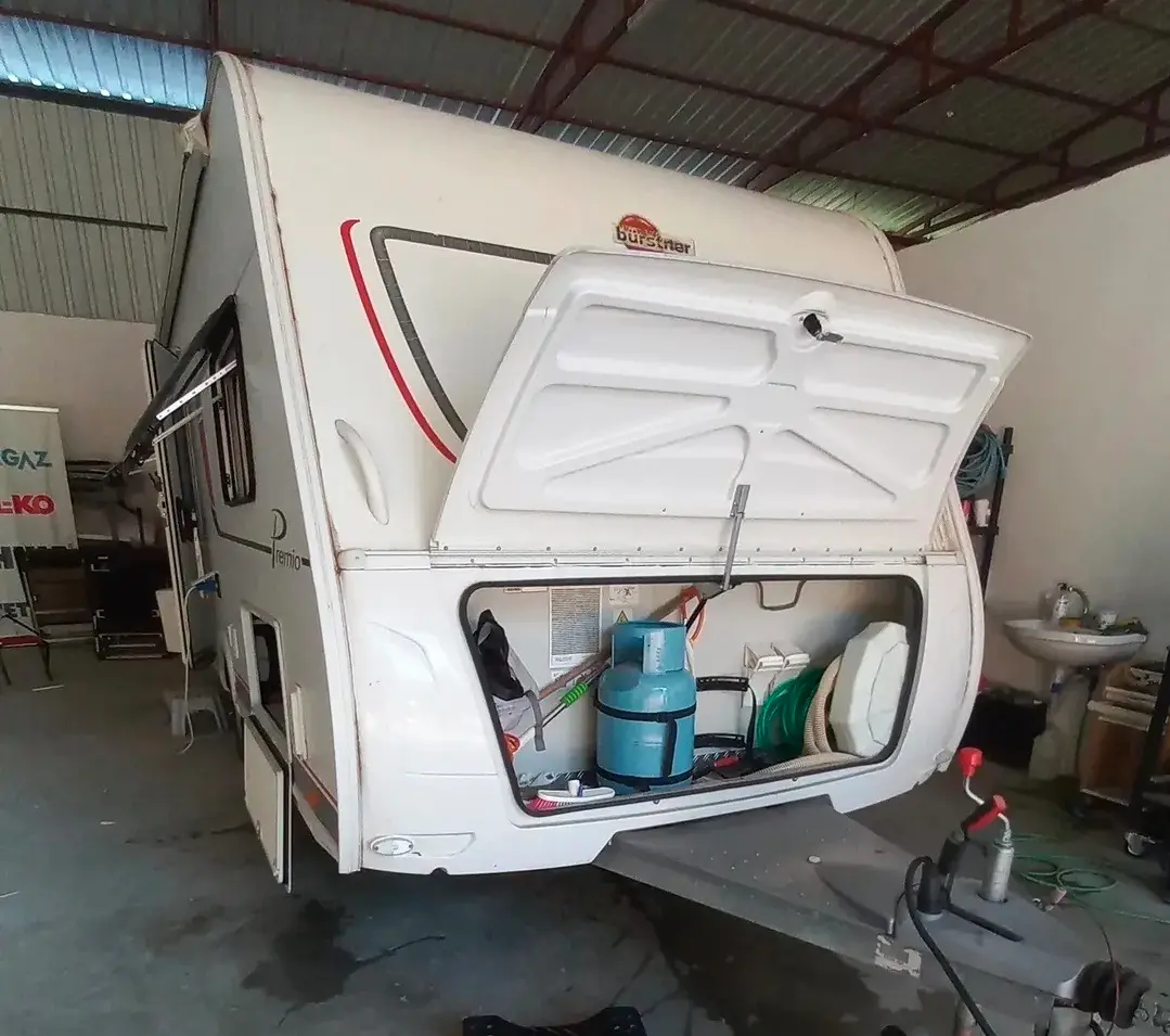 Ön bagaj kapağı açık karavan, içinde tüp ve tesisat